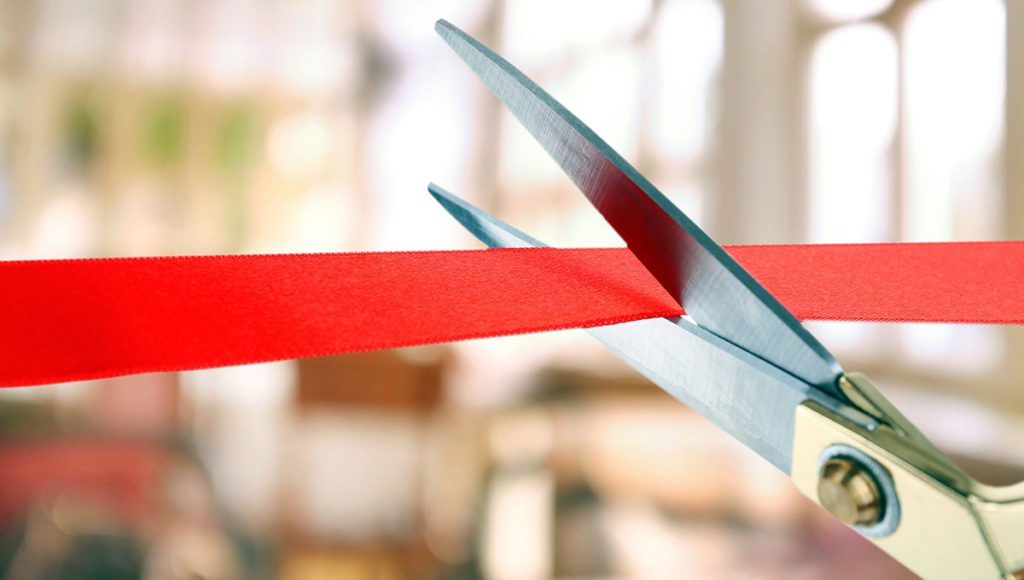 ribbon cutting with red ribbon and large scissors